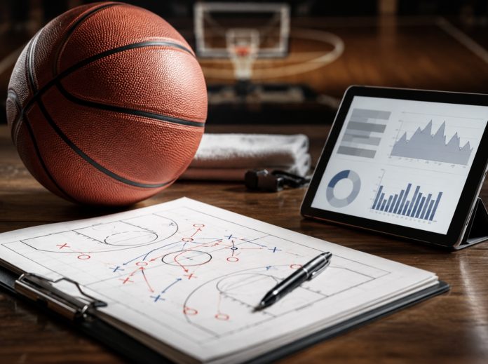 1 Basketball, tactic sheet and tablet with charts arranged on a court-side desk